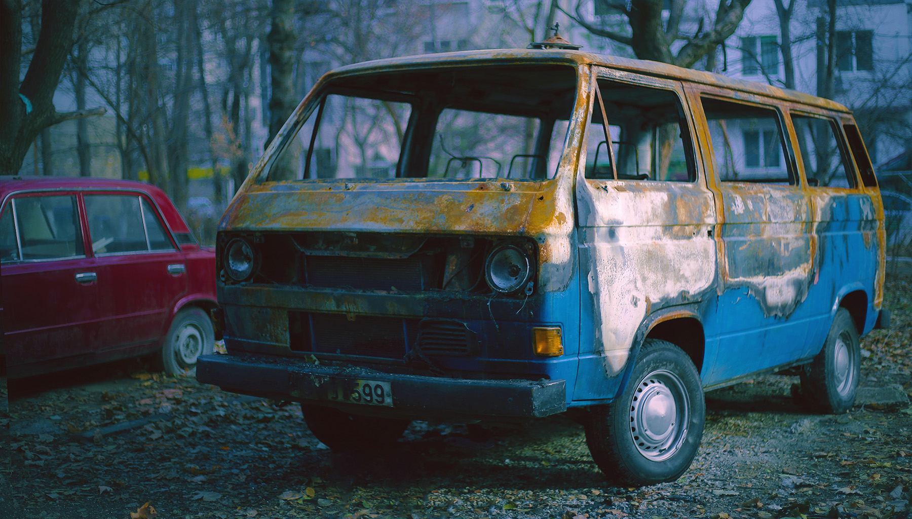 Old, weathered van in an overgrown field, showing signs of age and disuse.