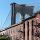 Brooklyn Bridge arching over historic brick facades in Brooklyn