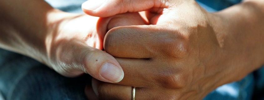 Person compassionately holding a veteran's hands in support.