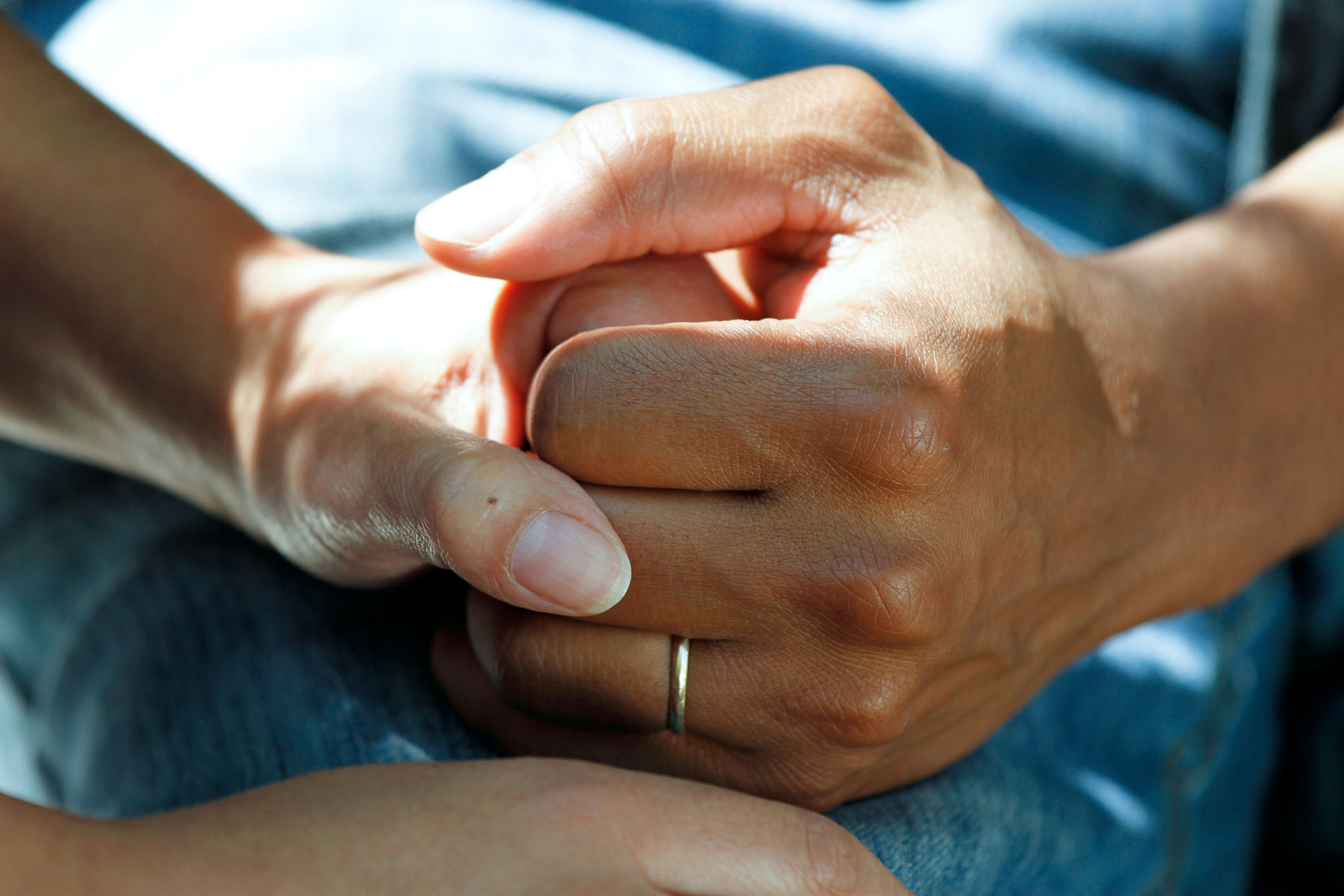 Person compassionately holding a veteran's hands in support.