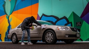 Man waxing a car to be donated to the Troops Relief Fund in Brooklyn