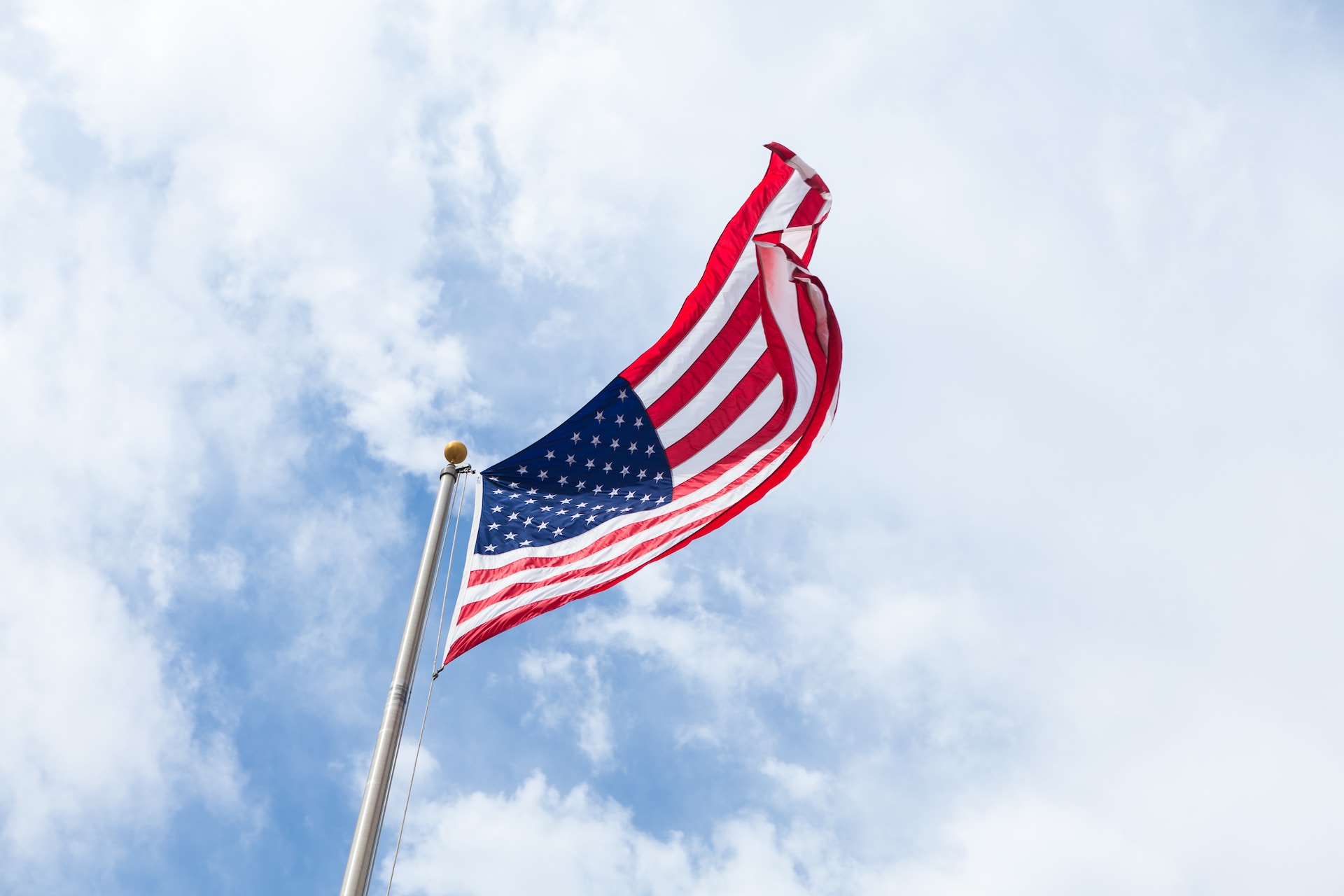 US flag flying against a backdrop of beautiful clouds, symbolizing patriotism in Brooklyn