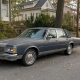 Antique sedan parked on a tree-lined Staten Island residential street