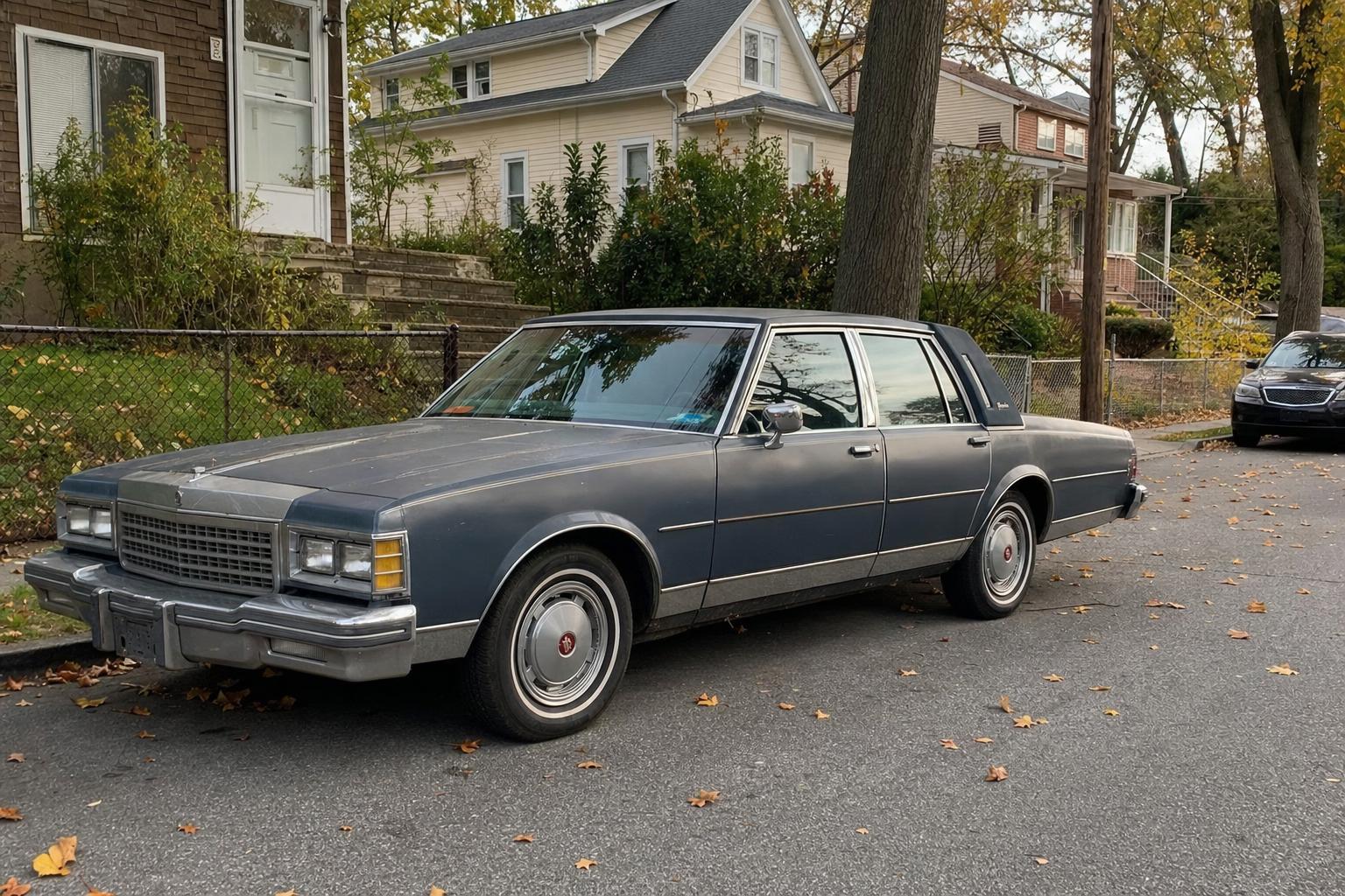 Antique sedan parked on a tree-lined Staten Island residential street