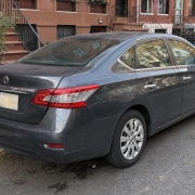A parked car on a Brooklyn residential block with rowhouses, stoops, and curbside parking