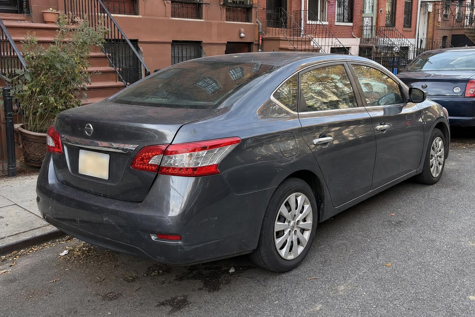 A parked car on a Brooklyn residential block with rowhouses, stoops, and curbside parking