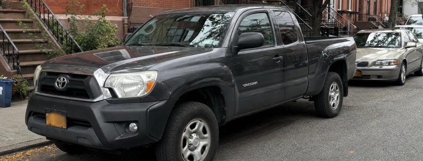 Pickup truck parked on a Brooklyn street near brick residential buildings