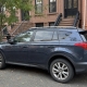 Unbranded vehicle parked beside brownstone stoops on a Brooklyn residential street