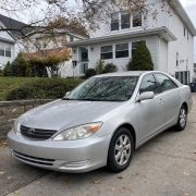 Parked Sedan in a Staten Island Driveway Silver sedan parked in a Staten Island driveway beside detached homes and mature trees.