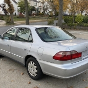 Silver sedan in a Staten Island driveway beside detached homes and autumn trees.
